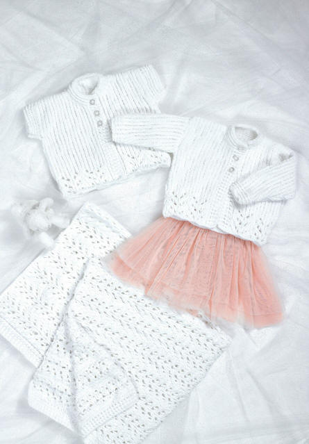 Picture shows a white sleeveless cardigan with a lower lacy edge, a white long sleeved cardigan with a lower lacy edge and a lacy white blanket.